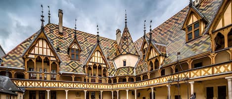 Un patio con un edificio tradicional, techo de tejas y estructura de madera.
