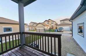 A residential area with multiple houses, a covered porch, and a gravel driveway.