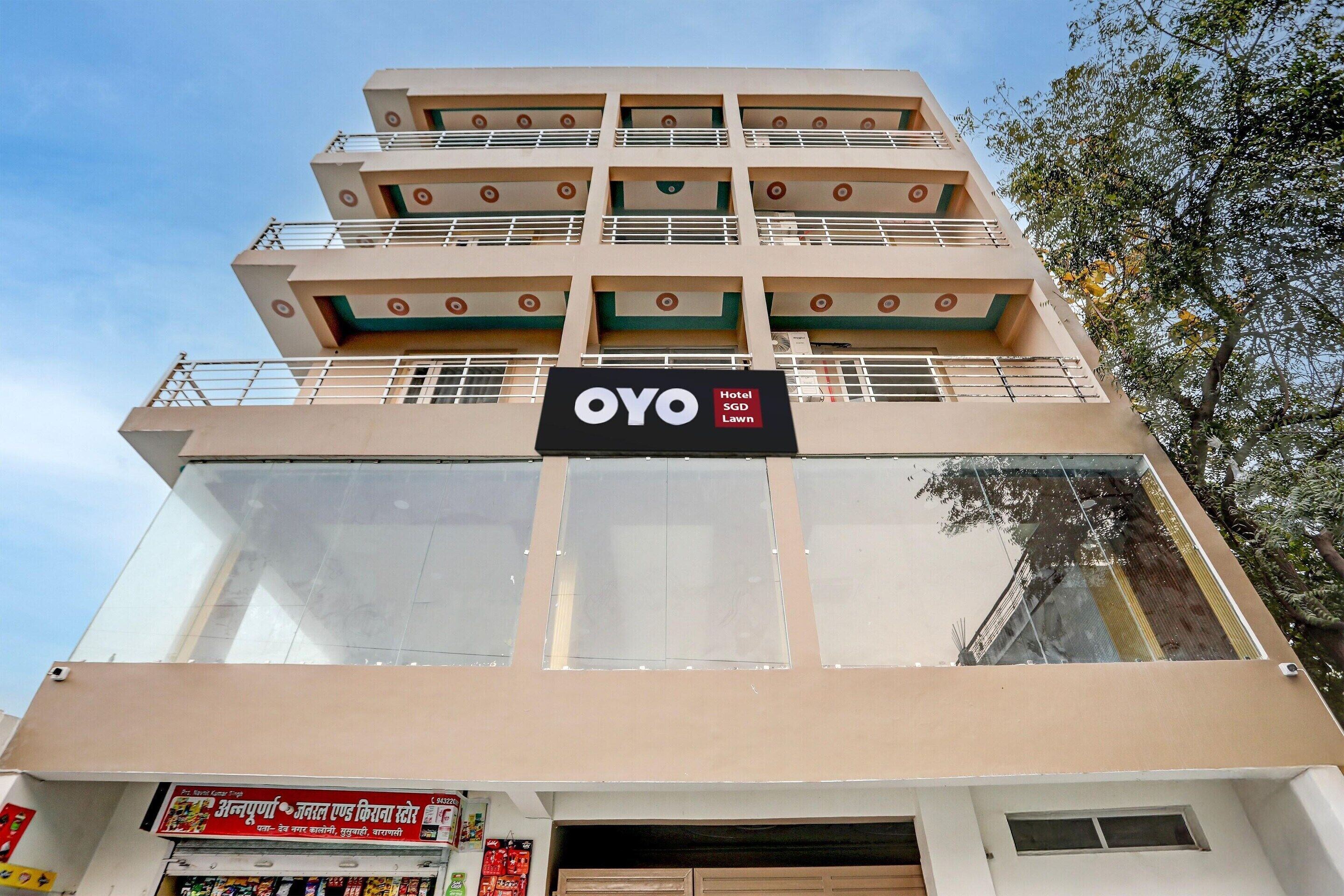 A multi-story hotel with a sign for OYO SGP Lawn.