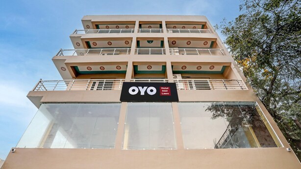 A multi-story hotel with a sign for OYO SGP Lawn. - Classic SGD Lawn And Hotel (Varanasi)