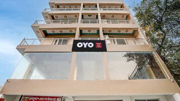 A multi-story hotel with a sign for OYO SGP Lawn.