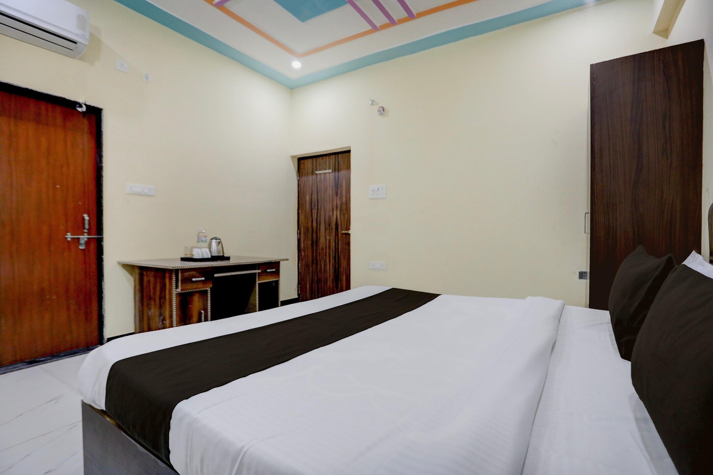 A hotel room with a bed, a desk, and a wardrobe.