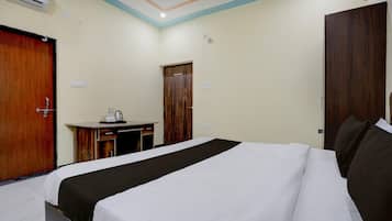 A hotel room with a bed, a desk, and a wardrobe.