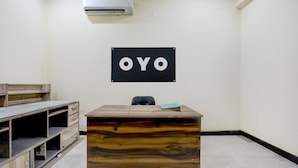 A reception desk with a sign that reads 'OYO' mounted on the wall. - Classic SGD Lawn And Hotel (Varanasi)