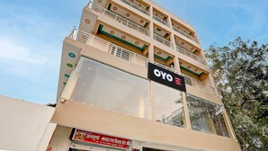 A multi-story hotel with balconies and a sign for OYO Hotel. - Classic SGD Lawn And Hotel (Varanasi)