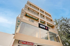 A multi-story hotel with balconies and a sign for OYO Hotel. - Classic SGD Lawn And Hotel (Varanasi)