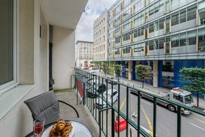 A balcony with a table, chairs, and a glass of red wine. - Lumina 3room Apart near Pałac Kultury (Warszawa)