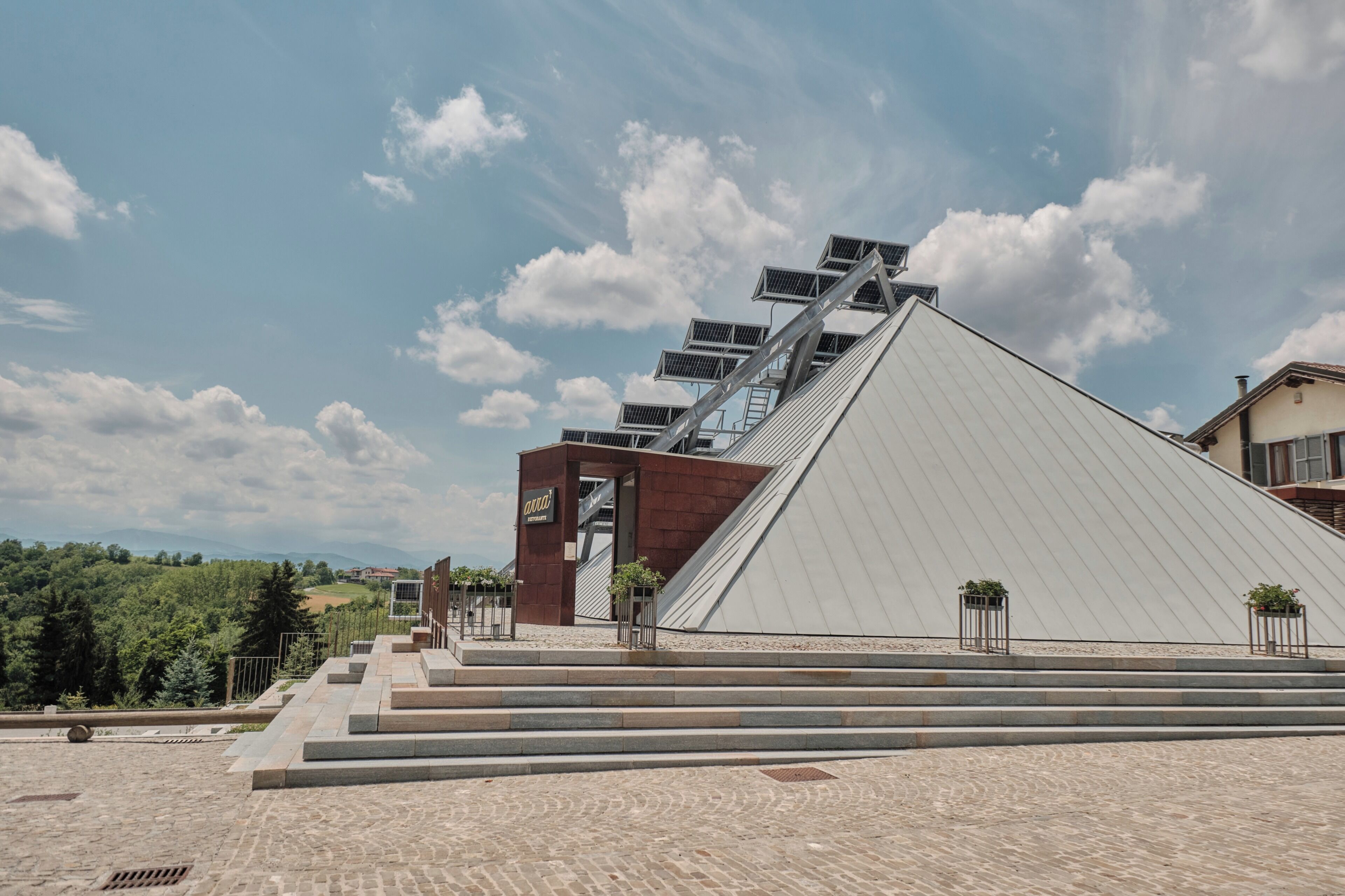 Un bâtiment moderne doté d’un toit en pente et de panneaux solaires.