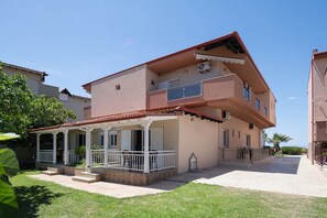 A multi-story residential building with a covered porch and a paved courtyard. - Studio Johanna A2 by Rentals Pro - Toroni Halkidiki (Toroni)
