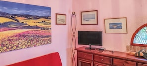 Ein Zimmer mit einem großen Landschaftsbild, einem Flachbildfernseher und einer Holzkabine.