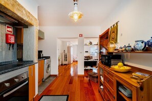 Une cuisine avec un plancher en bois, un lave-linge et un coin repas agrémenté d’un panier et d’objets décoratifs.