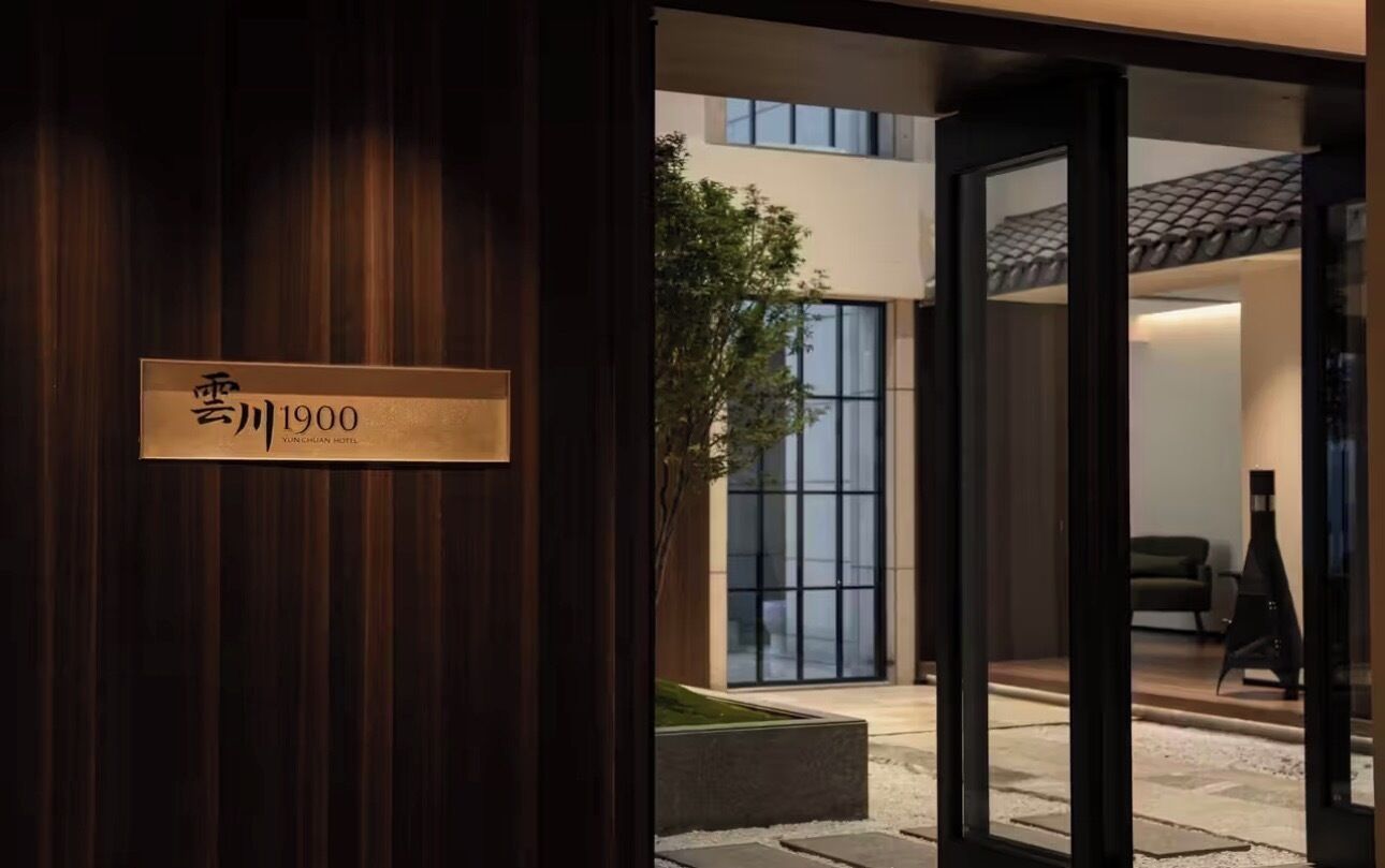 A hotel entrance with a wooden door and a sign indicating 'Yun Chuan Hotel'.