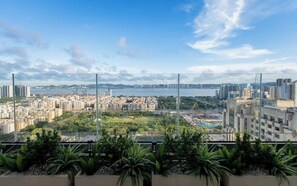 A high-rise building with a view of a cityscape and a body of water.