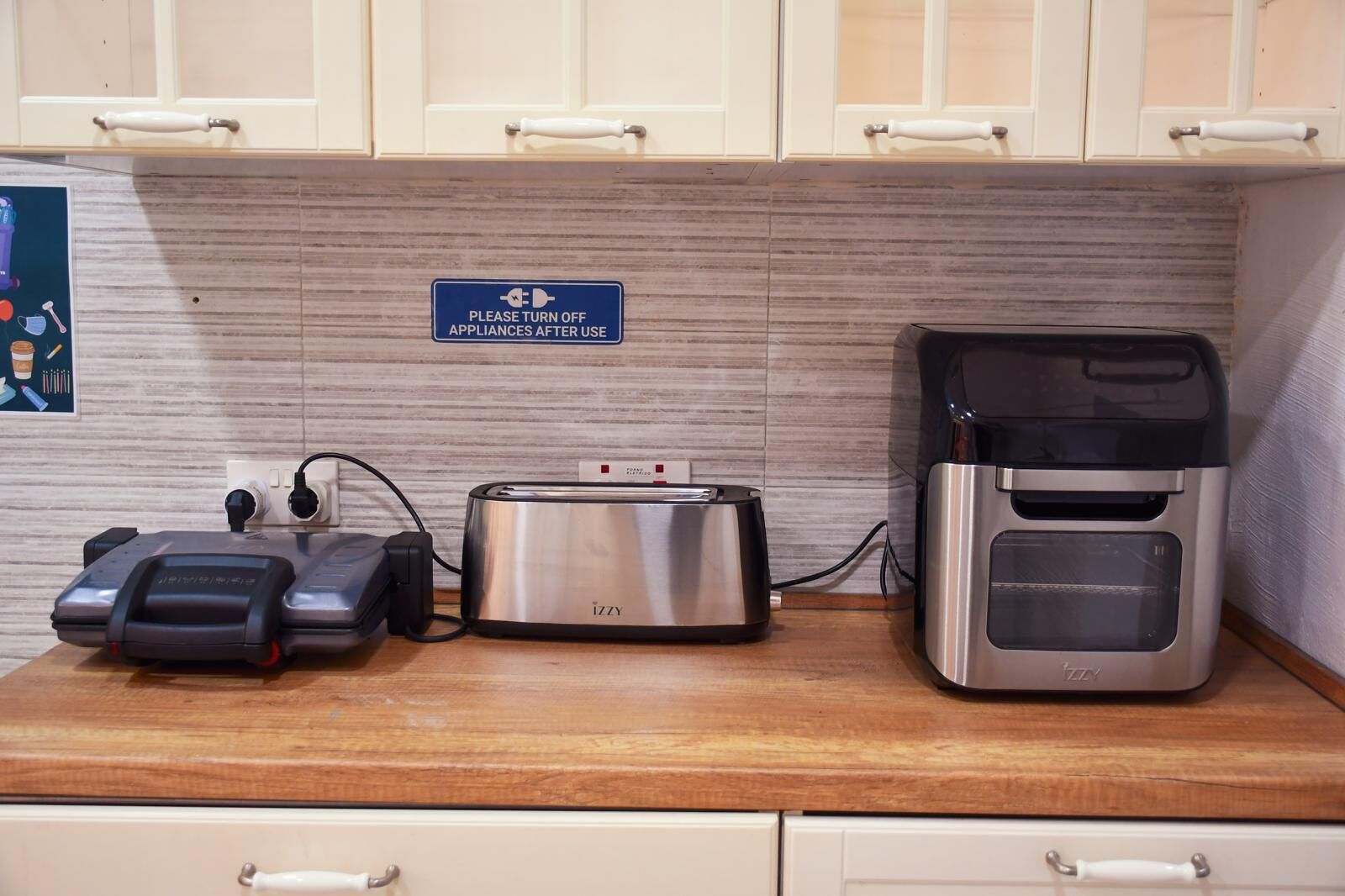 A kitchen counter with a toaster, a coffee maker, and a portable electric kettle.