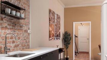 A modern kitchen with a brick wall, a large island, and a dining area with a table and chairs.