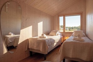 Quarto com duas camas, um espelho grande e janela com vista.
