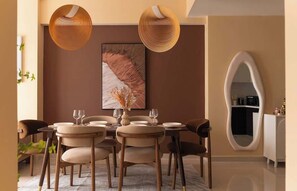 A dining area with a round table, chairs, and hanging pendant lights. - 3BR/4Beds | 2BA • Central D1 • Group Stay • Corner (Thành phố Hồ Chí Minh)