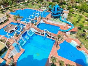 A large outdoor swimming pool complex with multiple interconnected pools and a water slide. - 1-Bedroom Apartment in Benalbeach with Pool, Private Terrace & Air Conditioning (Benalmádena)