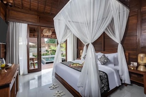A four-poster canopy bed with a view of a pool and garden. - Nadisa Villas by GenuineHost (Ubud)
