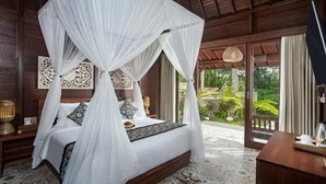 Un dormitorio con cama con dosel, suelo de madera y vistas a un jardín.