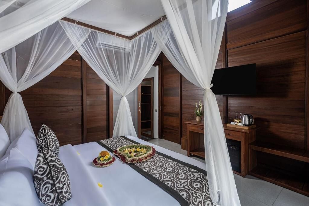 Una habitación con una cama, una mesita de noche, un televisor y una pared de madera.