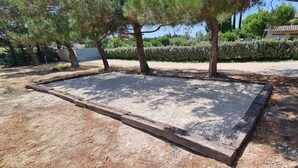 A gravel area with trees and a building in the background. - Room with bathroom, toilet, and terrace, 200 meters from the Saumane Golf Course (Saumane-de-Vaucluse)