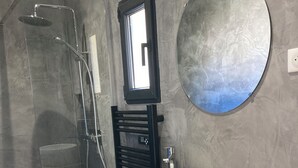A modern bathroom with a glass-enclosed shower, a round mirror, and a wooden vanity with a white sink. - Room with bathroom, toilet, and terrace, 200 meters from the Saumane Golf Course (Saumane-de-Vaucluse)