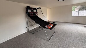 A basketball hoop with a net, a wall-mounted TV, and a window with a view of a brick structure. - Spacious 4-bedroom house in beautiful Bellevue with AC (Bellevue)