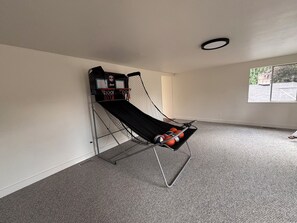 A basketball hoop with a net, a wall-mounted TV, and a window with a view of a brick structure. - Spacious 4-bedroom house in beautiful Bellevue with AC (Bellevue)