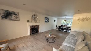 A spacious living room with a fireplace, a dining area, and a sofa. - Spacious 4-bedroom house in beautiful Bellevue with AC (Bellevue)