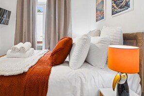 A hotel room with a bed, a white lamp, and a decorative bird sculpture. - HardenhuishHaus|Spacious 4BR|Group Stay|Parking (Brislington)