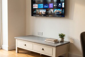 A modern room with a flat-screen TV mounted on the wall displaying various streaming services. - 2|Burnham-on-sea|Contractors|Couple|Sleeps2|WiFi (Somerset)
