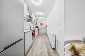 A narrow kitchen with white cabinets, a built-in oven, and a microwave. - 6|Bright Bristol Escape: Ideal for the Whole Group (Bristol)