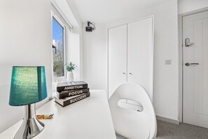A modern office space with a desk, a lamp, a chair, and a window with a view. - 6|Bright Bristol Escape: Ideal for the Whole Group (Bristol)