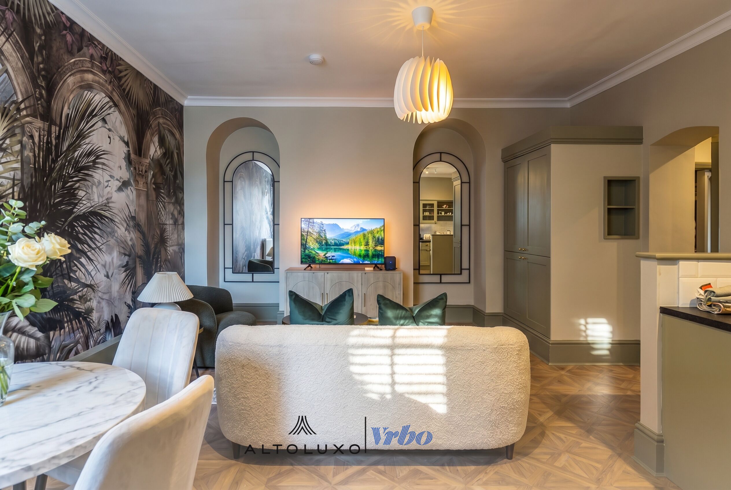 A modern living room with a sofa, TV, and decorative elements.