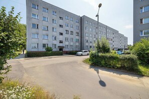 Un edificio residencial de varios pisos con un área de estacionamiento al frente.