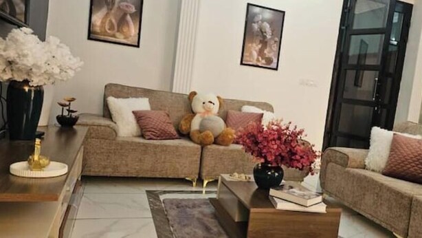 A living room with a sofa, a coffee table, and decorative items. - Cozy, Spotlessly Clean & Beautifully Appointed Luxury Apartment (Centre Region)