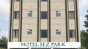 Ein mehrstöckiges Hotelgebäude mit einem Schild, auf dem 'HOTEL SEZ PARK BY DIVOY HOTELS & RESORTS' steht.