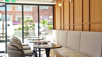 A modern interior with a seating area, tables, and a view of the outside.