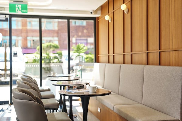 A modern interior with a seating area, tables, and a view of the outside. - Howard Residence (Taipei)