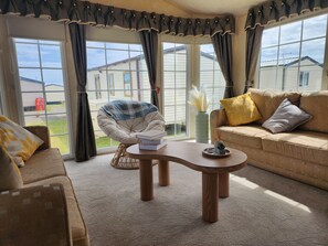 Ein gemütliches Wohnzimmer mit Sofa, Sessel und Couchtisch.