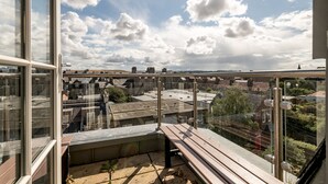 Un balcon offrant une vue sur le paysage urbain, avec des bâtiments et un pont.