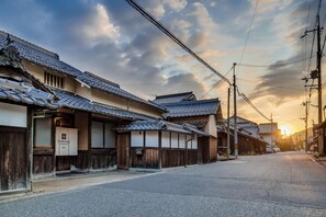 A traditional Japanese street with wooden buildings and a clear sky. - Nipponia Fukusumi Shukubamachi (Sasayama)