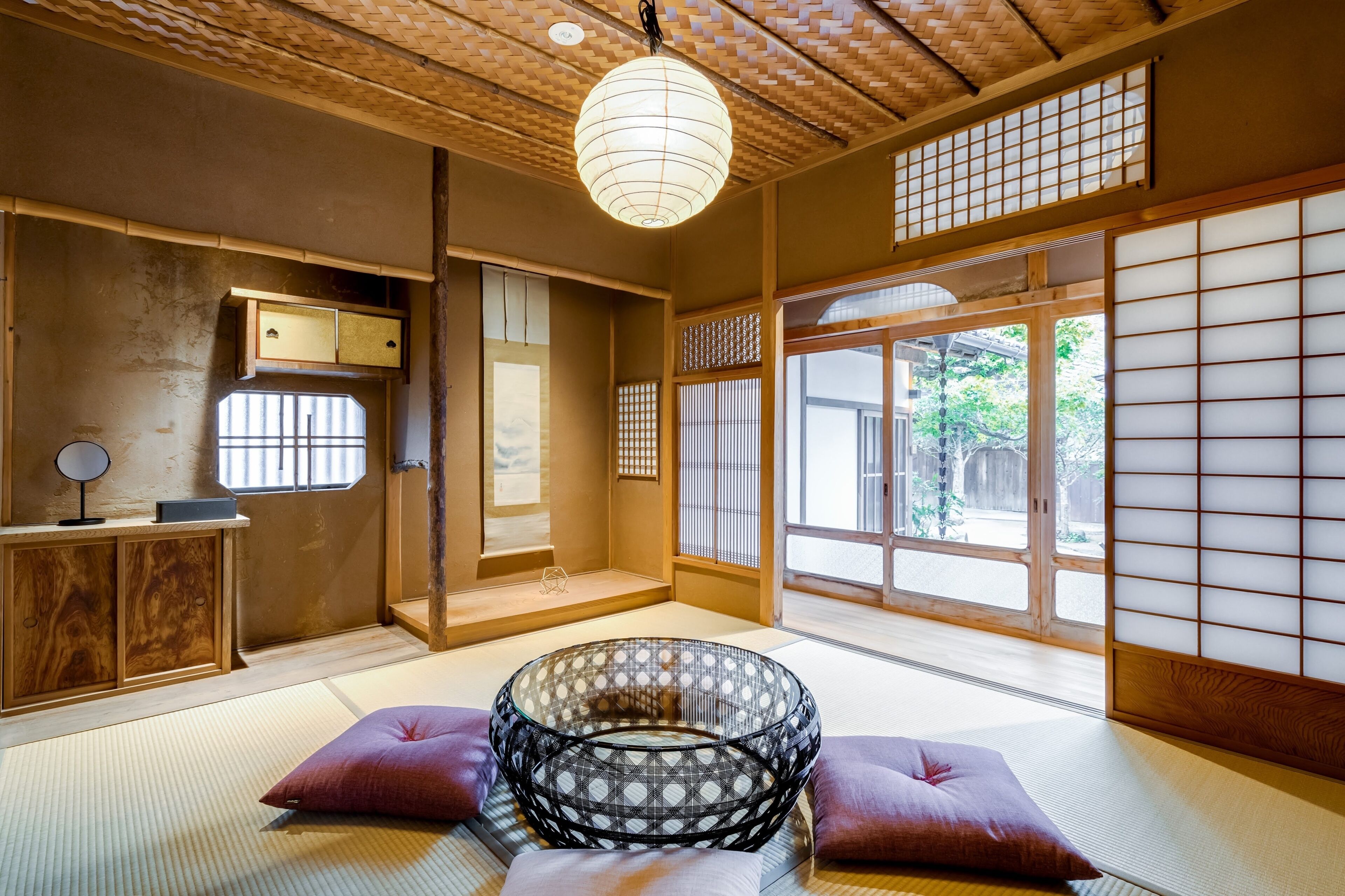 A traditional Japanese room with tatami flooring, a shoji screen, and a hanging paper lantern.