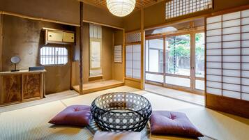 A traditional Japanese room with tatami flooring, a shoji screen, and a hanging paper lantern.
