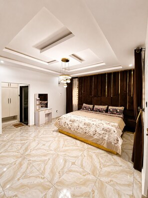 A bedroom with a large bed, a vanity, and a wardrobe. - Grand 4BR Luxury Duplex near Airport – 15 mins from airport (Benin)