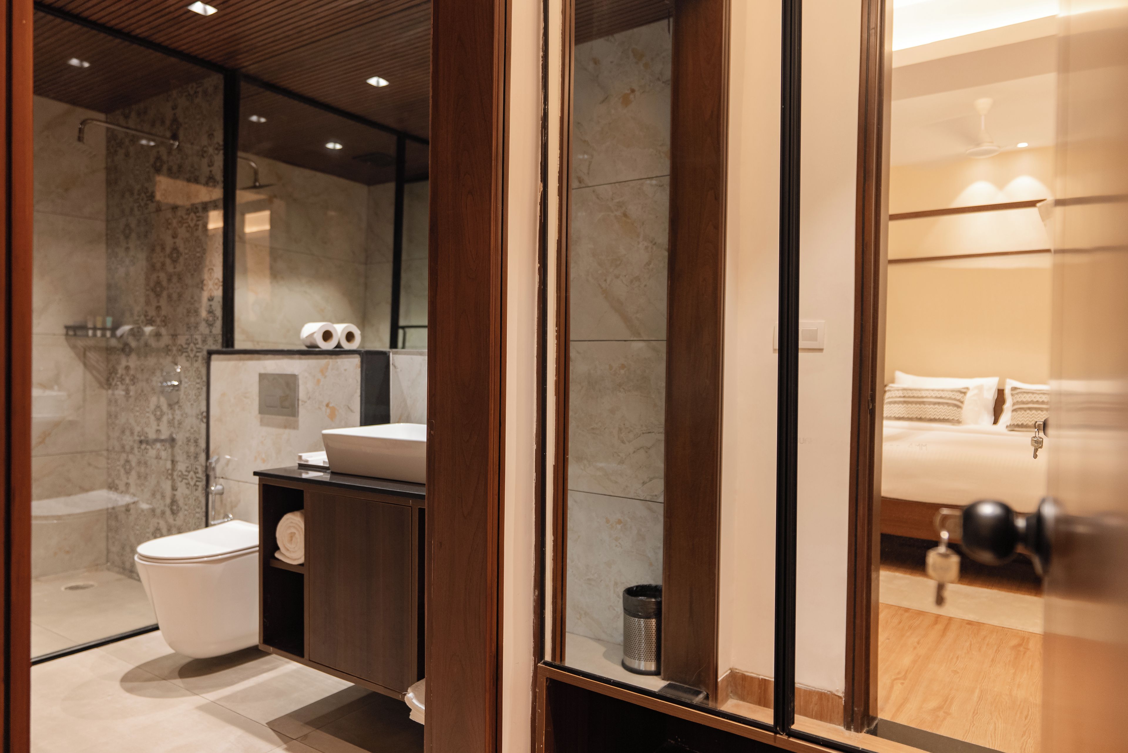 Un baño moderno con cabina de ducha de vidrio, inodoro, lavabo y espejo.