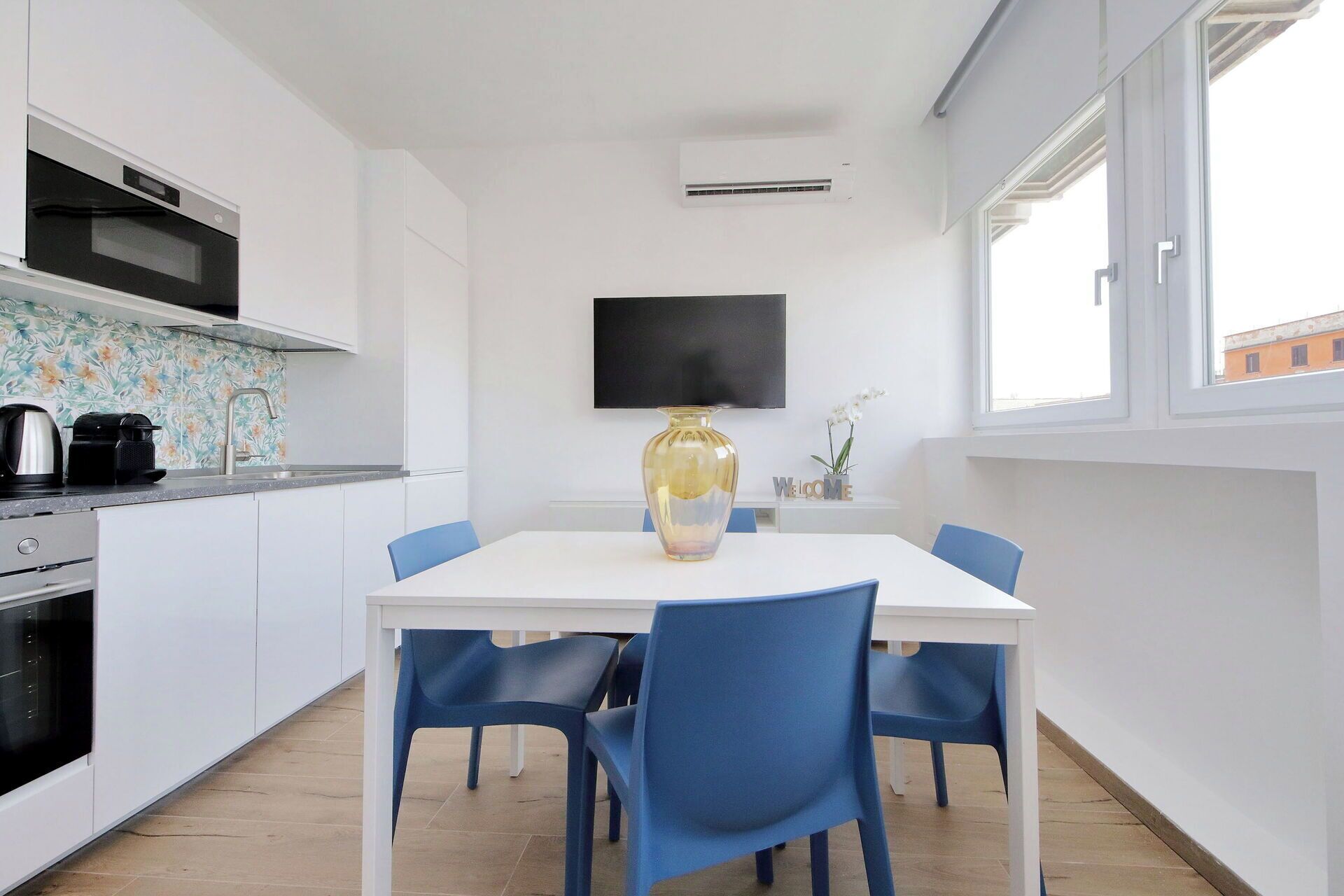 Una cocina moderna con armarios blancos, horno negro y salpicadero de azulejos.