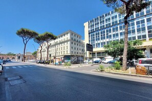 Eine Straße mit Gebäuden, Bäumen und parkenden Autos.