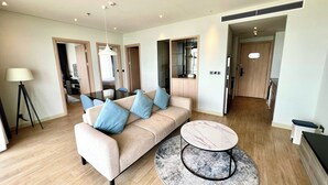 A modern living room with a sofa, a round coffee table, and a lamp. - CMH Homestay A side - 5star standard (Halong City)